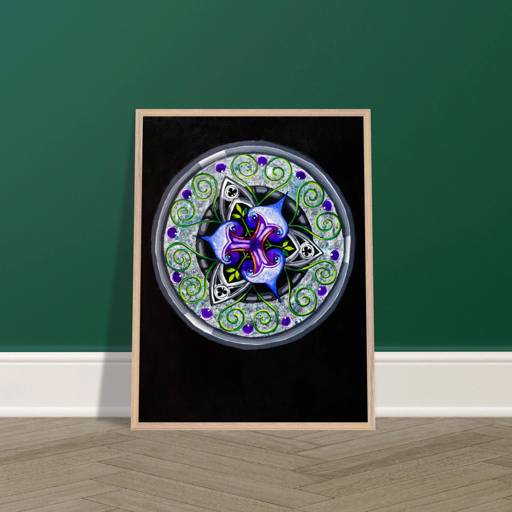 Framed abstract blue and purple artwork with green tendrils displayed on a wall in a styled room setting, showing scale and how the art looks when hung.